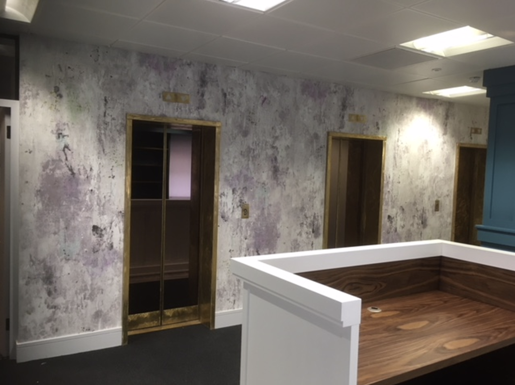 A workspace with a desk and a striking purple wall, creating a modern atmosphere
